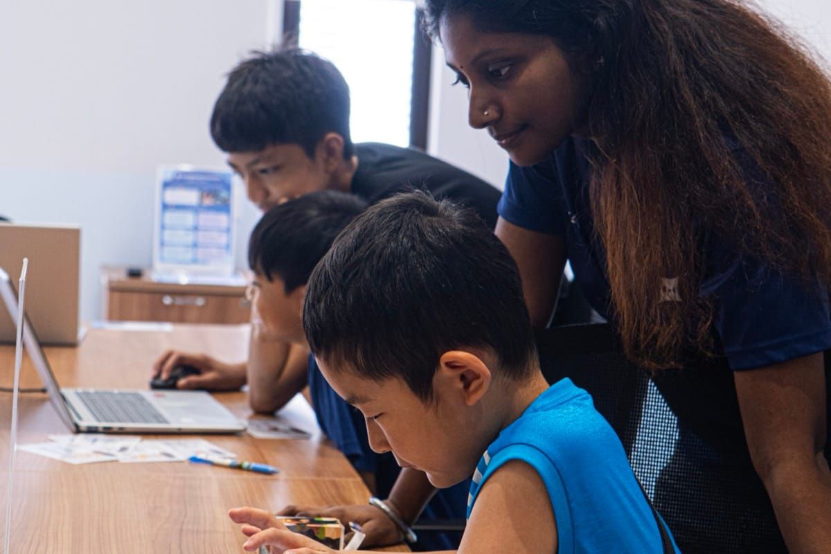 Teacher guiding a student at KURAI