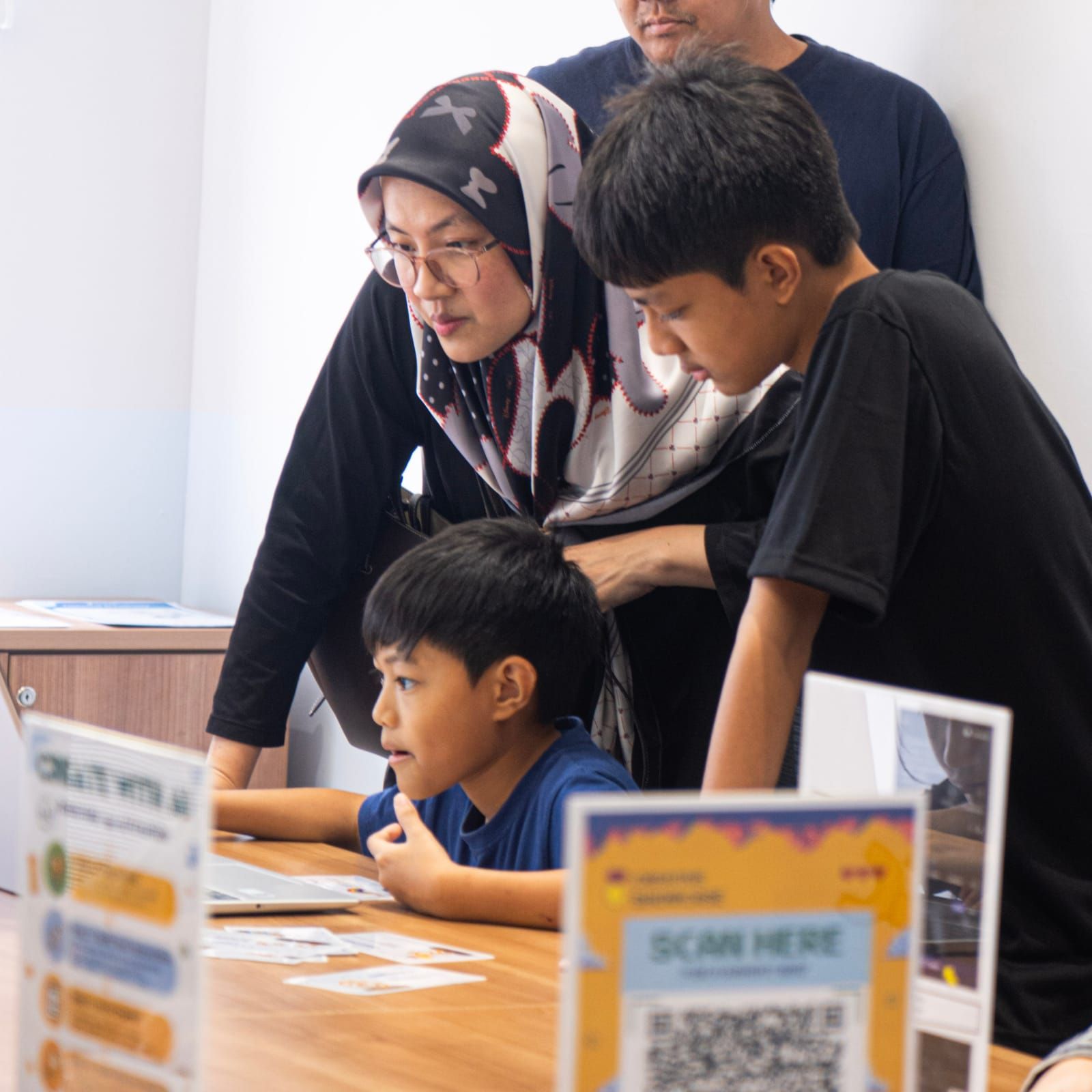 Family watching students work at KURAI