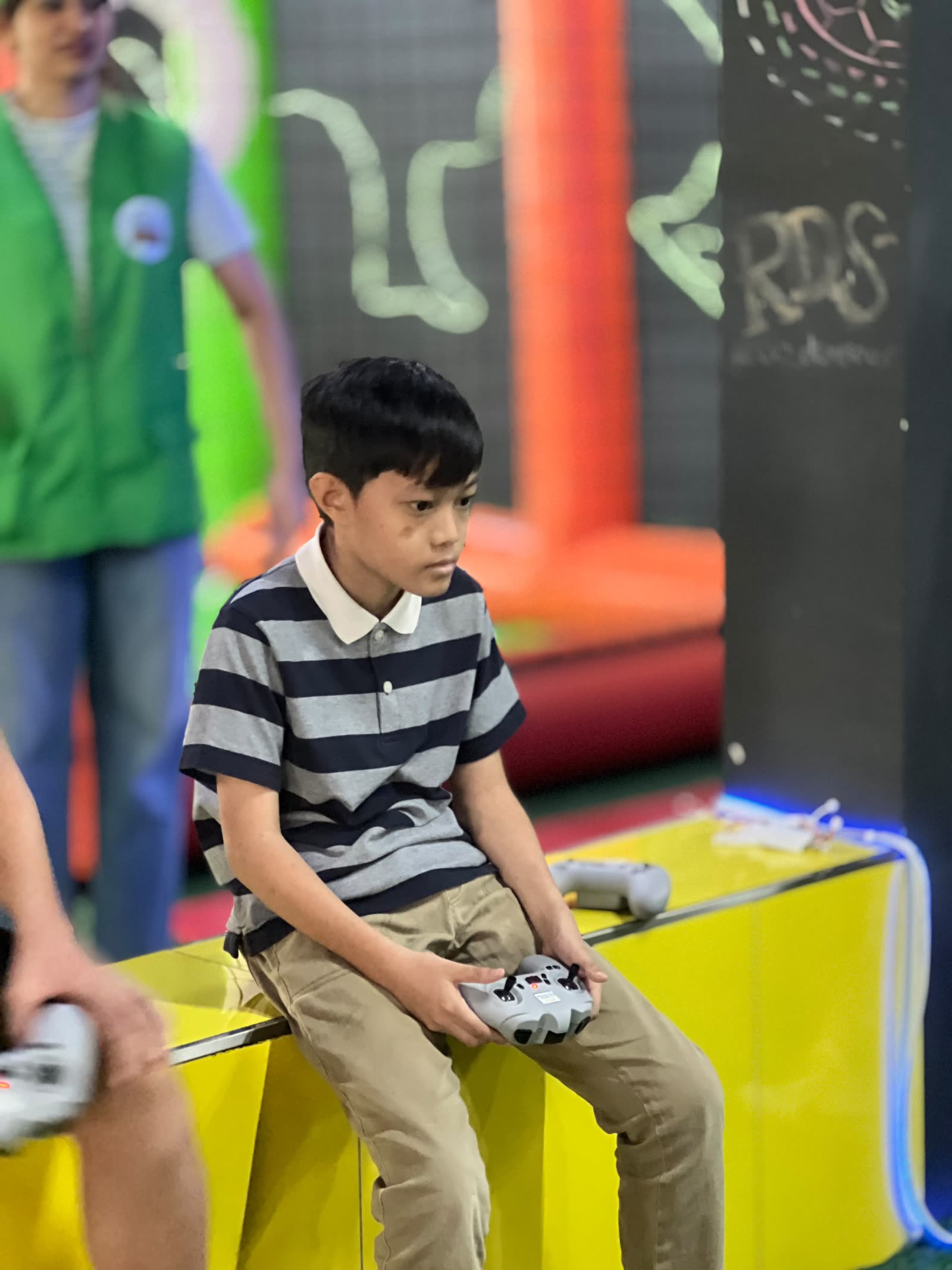Anas sitting at the arena with a drone controller in his hands