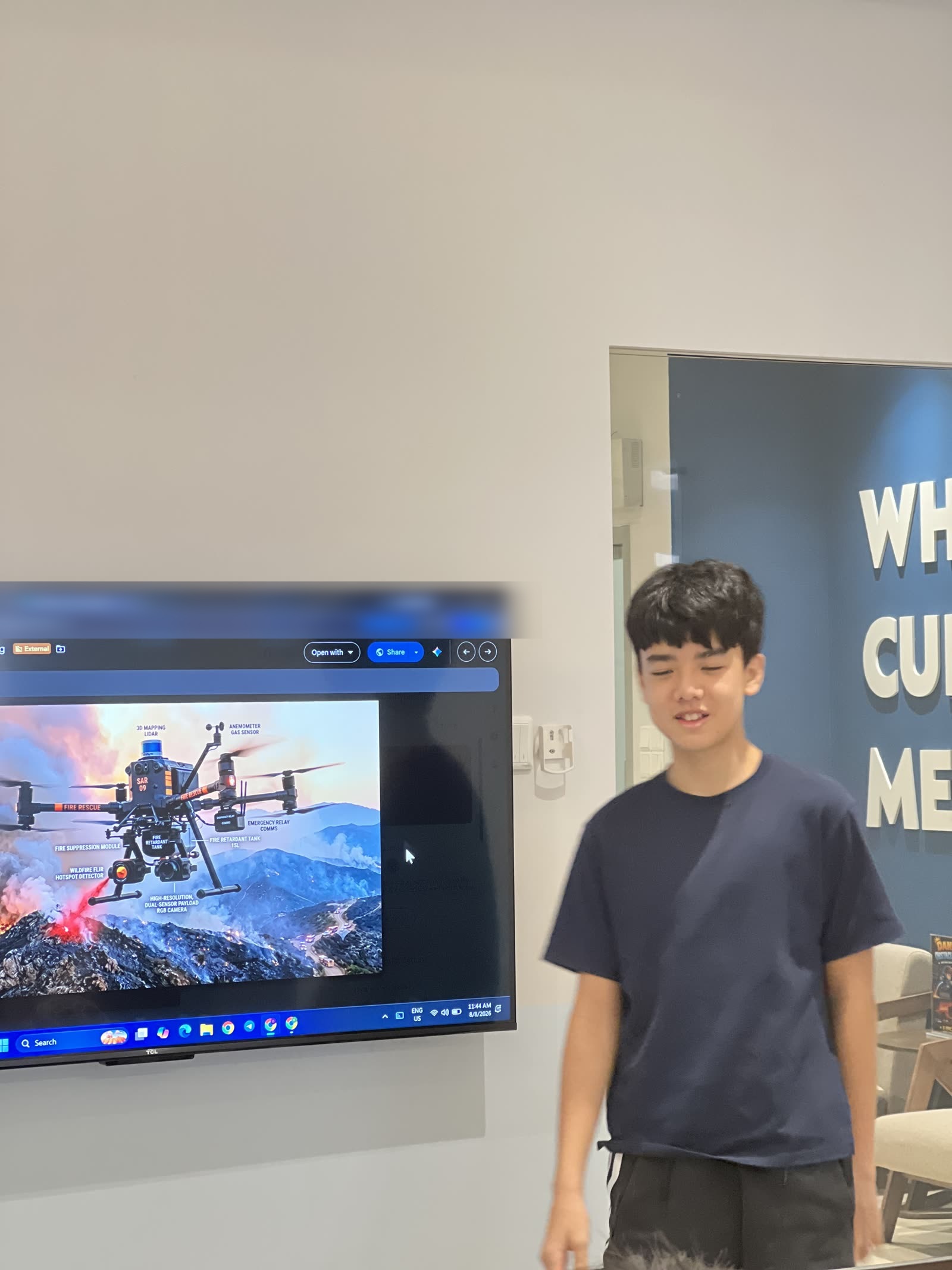 His wildfire drone, labelled part by part, up on the big screen.